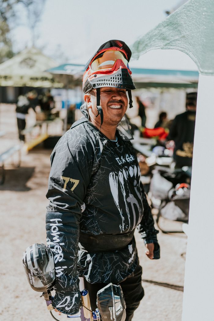 services-04 A happy man with paintball gear and protective mask outdoors, ready for action.