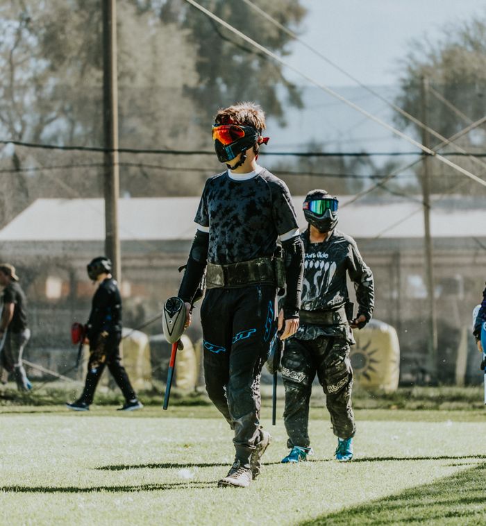 Young paintball players in action gear during a competitive outdoor match.